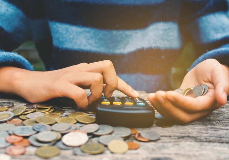 Hands,Girl,Holding,Calculator,And,Coin,Selective,And,Soft,Focus